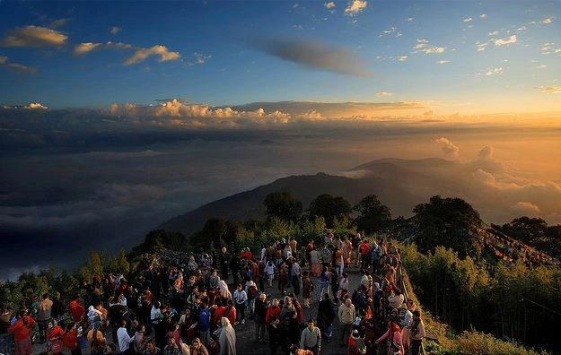 Tourists enjoying scenic Tsomgo Lake surrounded by mountains during Gangtok sightseeing tour.