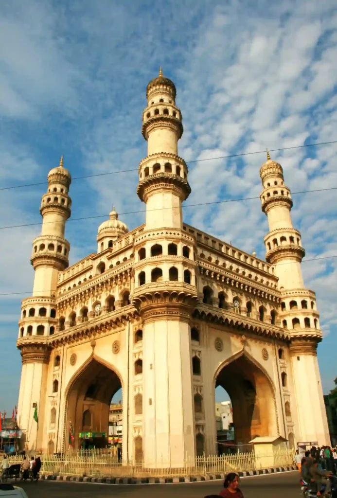 Charminar in Hyderabad, Telangana—the historic 16th-century monument and mosque featuring four grand arches and towering minarets against a cloudy blue sky.